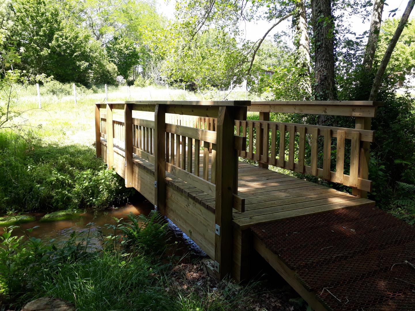 Passerelle en bois traversant le Launet pour se rendre à l'arboretum
