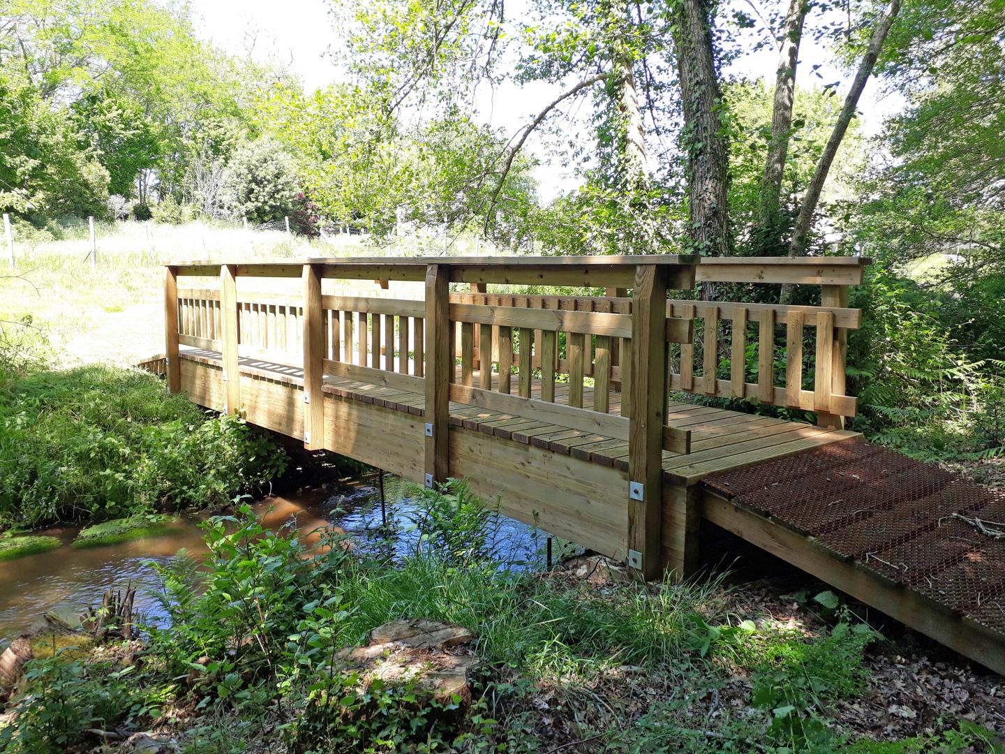 Passerelle en bois traversant le Launet pour se rendre à l'arboretum