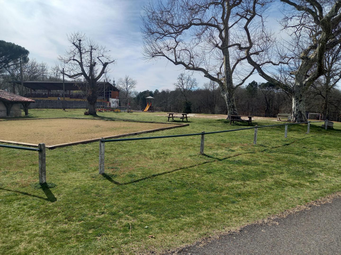 Terrain de pétanque au 1er plan et aire de jeux pour enfants à l'arrière plan